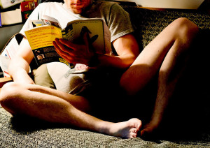 Ein Mann ließt Spirulina Bücher auf dem Sofa